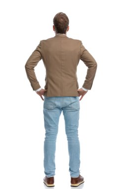 rear view of a businessman holding his hands on his waist and posing against white background