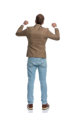 rear view of a businessman celebrating success and standing against white background