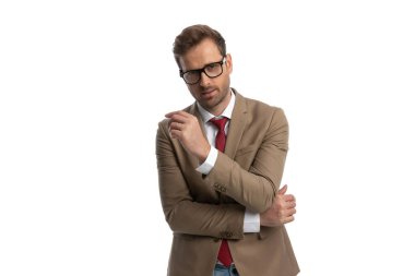 young businessman sensually folding his arms and wearing eyeglasses in a fashion pose