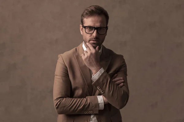 Serious Businessman Scratching His Chin Posing Attitude Brown Background Studio — Zdjęcie stockowe