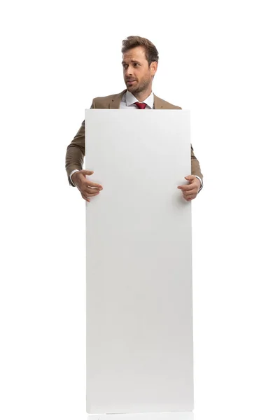 Handsome Businessman Holding His Vertical Board Looking Side White Background — Stock Fotó
