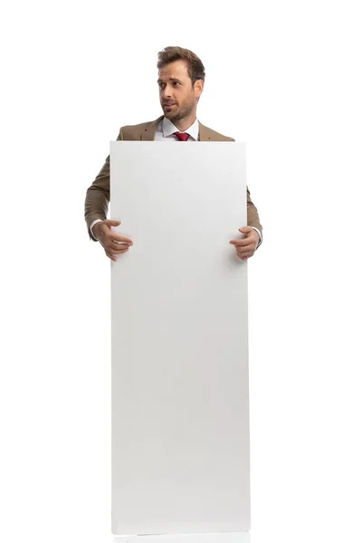 Handsome Businessman Holding His Vertical Board Looking Side White Background —  Fotos de Stock