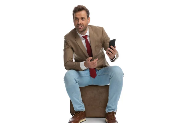 Hombre Negocios Sentado Señalando Teléfono Señalando Que Está Ocupado Contra — Foto de Stock