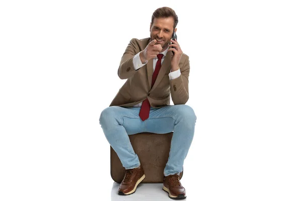 Seated Businessman Pointing Camera While Talking Phone White Background — Zdjęcie stockowe
