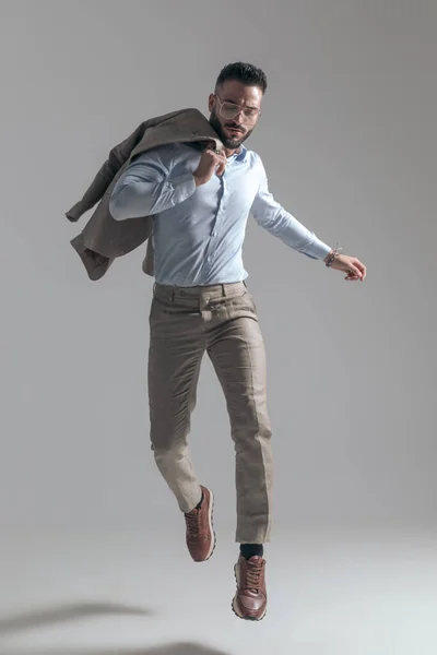 Cool Unshaved Businessman Glasses Holding Jacket Shoulder While Jumping Air — 스톡 사진