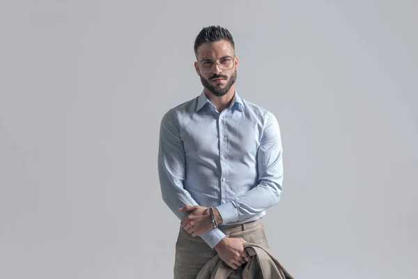 Handsome Unshaved Man Wearing Glasses Holding Jacket While Standing Grey — Stock Photo, Image