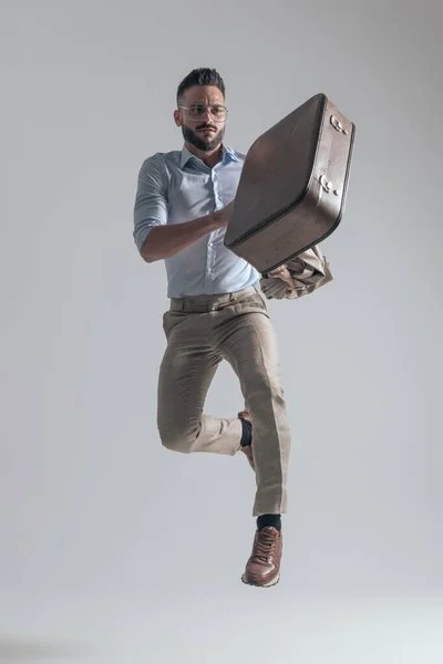 Cool Young Fashion Model Leaping While Holding Jacket Briefcase Grey — Stok fotoğraf