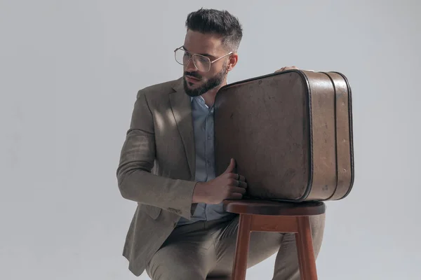 Handsome Businessman Glasses Looking Side Crouching Next Suitcase Wooden Chair —  Fotos de Stock