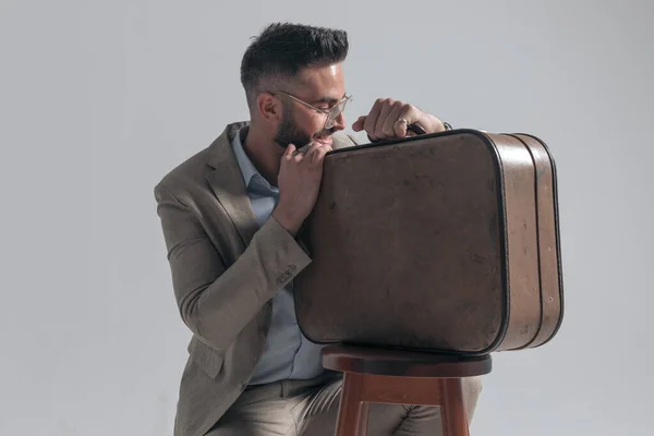 Sexy Unshaved Businessman Holding Suitcase Looking Side Smiling Grey Background — Zdjęcie stockowe