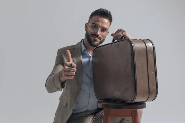 Happy Unshaved Man Smiling Holding Suitcase Making Thumbs Gesture While — Stok fotoğraf