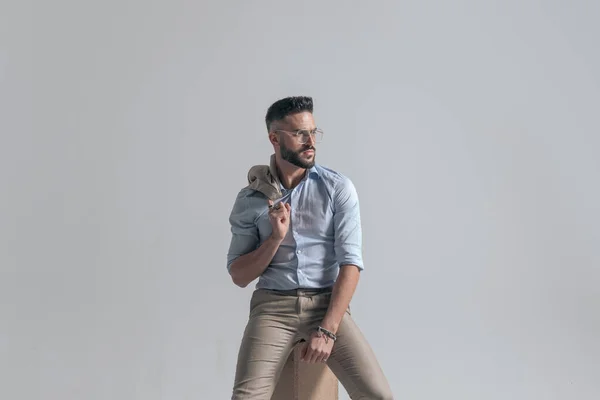 Portrait Seated Young Man Looking Side Holding Jacket Shoulder Grey — Stockfoto