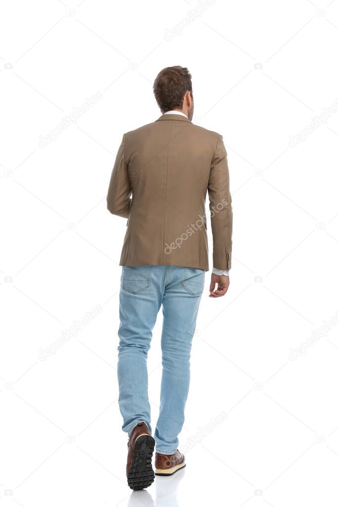 rear view of a businessman wearing a brown suit and walking away against white background