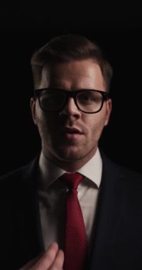 bearded businessman in elegant suit arranging hair, suit and tie, fixing glasses, being confident and walking away in a mysterious manner