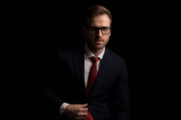 Handsome Businessman Adjusting His Suit Wearing Eyeglasses Posing Dark Background — Stock Photo, Image