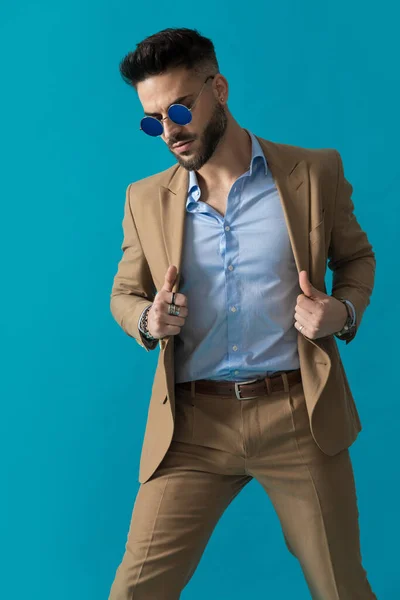 Unshaved Businessman Retro Sunglasses Adjusting Suit Looking Blue Background Studio — Stock Photo, Image