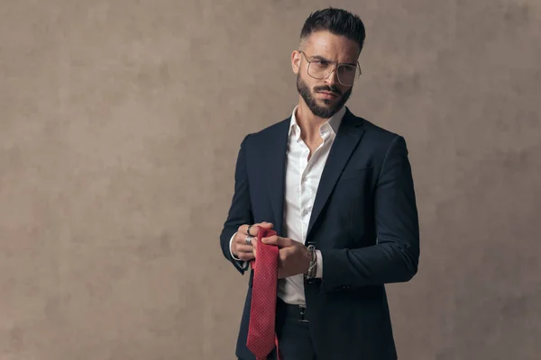 Atraente Elegante Homem Negócios Segurando Sua Gravata Olhando Para Longe — Fotografia de Stock