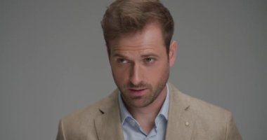 Çekici iş adamı heyecanlı ve gri arkaplana karşı başarıyı kutluyor