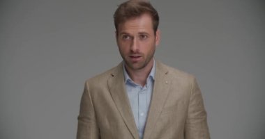 İş adamı zaferi gri arkaplana karşı coşkuyla kutluyor