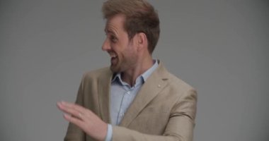 İş adamı koşuyor, insanları selamlıyor, gülümsüyor ve başarıyı kutluyor.