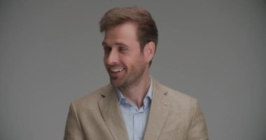 Mutlu iş adamı kameraya gülümsüyor, sağa sola bakıyor ve gülüyor.