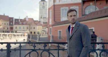 Yüzünde bir gülümsemeyle bir tarafa bir ileriye bakan bir iş adamının yan görüntüsü.