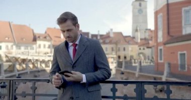 Çekici bir iş adamı telefonuna yazı yazar sonra konuşur ve güzel bir sohbet eder.