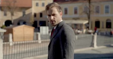 Seksi bir iş adamının yan görüntüsü. Sonra kameraya arkasını dönüyor.