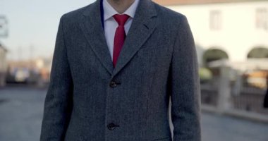 Yakışıklı iş adamı kameraya gülümsüyor ve güzel bir takım elbise ve ceket giyiyor.