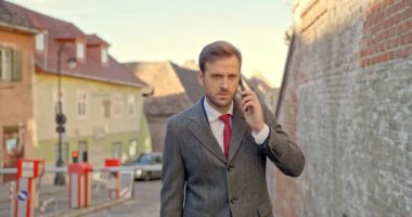 Ortaçağdan kalma bir kasabanın arka planında telefonla konuşurken meşgul genç bir işadamı yürüyor, uzaklara bakıyor ve şehre hayran.