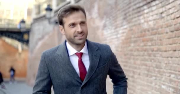 Junger Geschäftsmann Läuft Einer Mauer Entlang Und Lächelt — Stockvideo