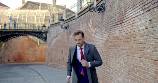 양복을 외투를 매력적 사업가가 도시에서 가출하는 모습을 비디오 — 비디오