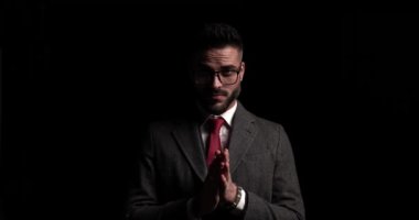 İş adamı avuçlarını ovalıyor ve yüzünde erkeksi bir gülümseme var.