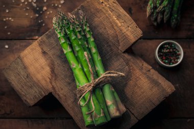 Bir grup kuşkonmaz bir kabloyla bağlanmış ve eski ahşap bir masanın üstünde eğilmiş. 