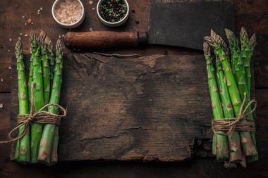 İki taze kuşkonmaz antika ahşap helikopterin tepesinde mesajınız için aralarında boşluk var. Tuz ve biberin yanında ve ahşap bir masada eski model bir satır.