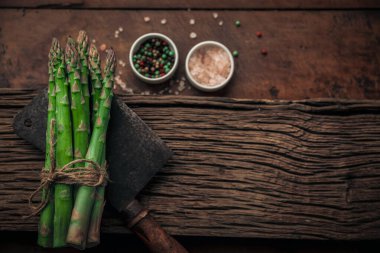 Taze sebzeler ve eski bir satır. Eski bir ahşap tahtanın tepesinde. Kırsal bir masanın üzerinde tuz ve biber var.