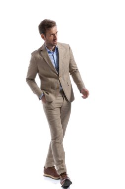 Yakışıklı, akıllı, sıradan bir adam yürüyor sonra yön değiştiriyor, bir elini cebine atıyor ve başka tarafa bakıyor.