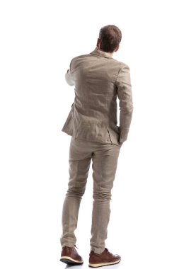 Bir iş adamının arka planı, beyaz arka planda bir eli cebinde bir şey düşünürken.