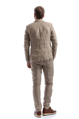 Kameraya arkasını dönen ve beyaz arka plana bakan bir iş adamının dikiz görüntüsü