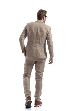 Çekici iş adamı elini cebine atmış, beyaz arka planda gözlük takıyor.