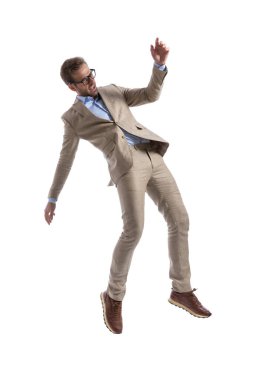 Çekici iş adamı arkasına yaslanıyor, şok olmuş hissediyor ve beyaz arka planda gözlük takıyor.