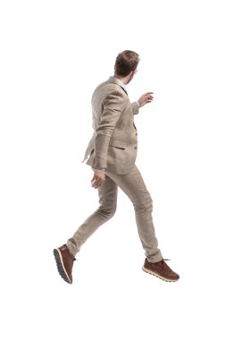 Bir iş adamının bir yöne yürüyüp, diğer tarafa beyaz arka planda bakmasının yan görüntüsü