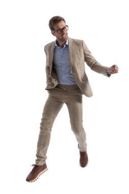 Seksi iş adamı bir eli cebinde, yana bakıyor ve gözlük takıyor.