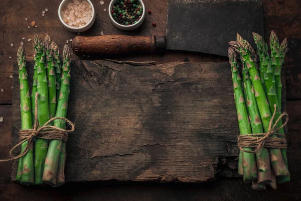 İki taze kuşkonmaz antika ahşap helikopterin tepesinde mesajınız için aralarında boşluk var. Tuz ve biberin yanında ve ahşap bir masada eski model bir satır.