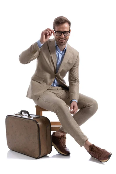 英俊的商人高兴极了 他把眼镜摆好 坐在公文包旁边的椅子上 — 图库照片