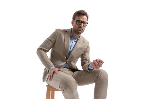 Siedzący Przystojny Biznesmen Spoczywający Kolanach Noszący Okulary Pozujący Białym Tle — Zdjęcie stockowe