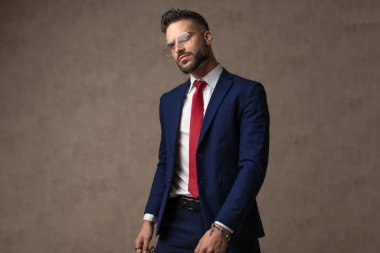 Çekici bir manken yüzüne sert bir bakışla bakıyor ve duvar kağıdına karşı poz veriyor.