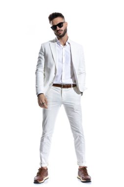 Güneş gözlüklü sakallı iş adamı el ele tutuşup stüdyoda beyaz arka planda poz veriyor.