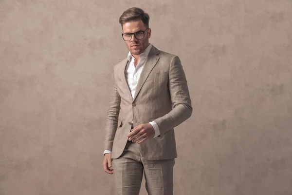 スマートなカジュアルな服装でセクシーな若い男の肖像画 眼鏡をかけ スタジオでベージュの背景の前でポーズ — ストック写真