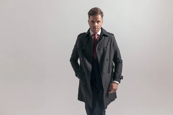 長いコートのポケットに手をつないでスーツを着た魅力的なビジネスマンの肖像画 — ストック写真