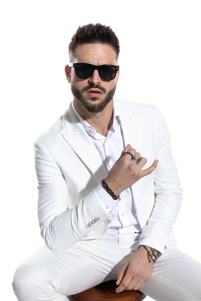 Bärtiger Geschäftsmann Mit Sonnenbrille Ellbogen Oberschenkel Und Posiert Auf Weißem — Stockfoto